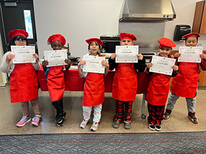 Six students holding their certificates of completion in culinary