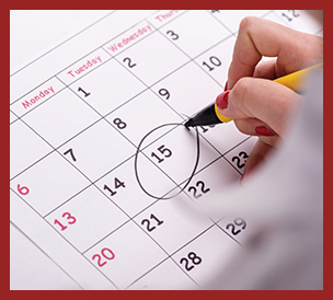 closeup of calendar with hand holding pencil and a date circled