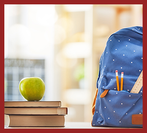 stacked books with green apple on top, blue backpack with pencil and ruler in pocket