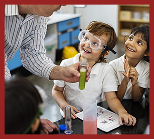 teacher showing students with safely goggles science experiment